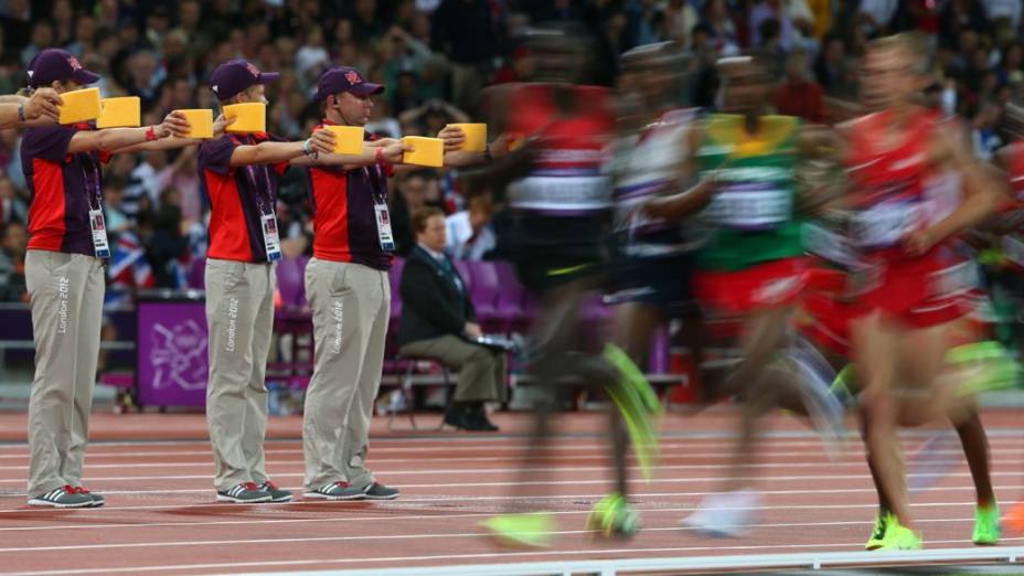 Voluntários na pista de atletismo do Estádio Olímpico de Londres