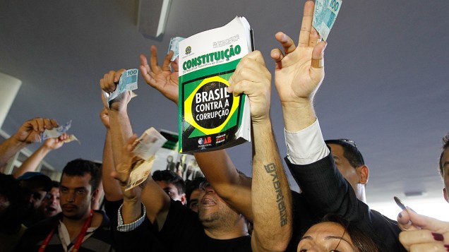 Manifestantes mostram a Constituição e notas de dinheiro em protesto contra a votação da mudanças feitas pelo governo federal na LDO tentam entrar no Congresso Nacional e são barrados pela segurança da Casa