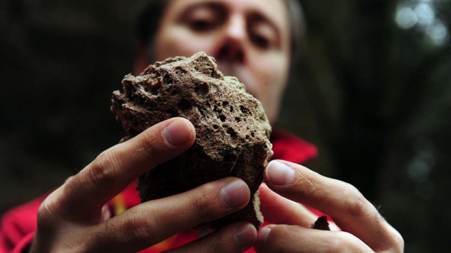 Homem mostra pedra vulcânica na cidade de Cardeal Samoré Pass, fronteira entre Chile e Argentina