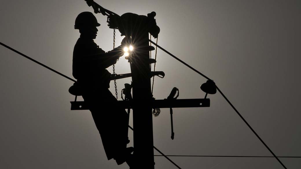 Manutenção de poste de energia elétrica em Yingtan, na China, que sofre com falta de luz assim como resto do país