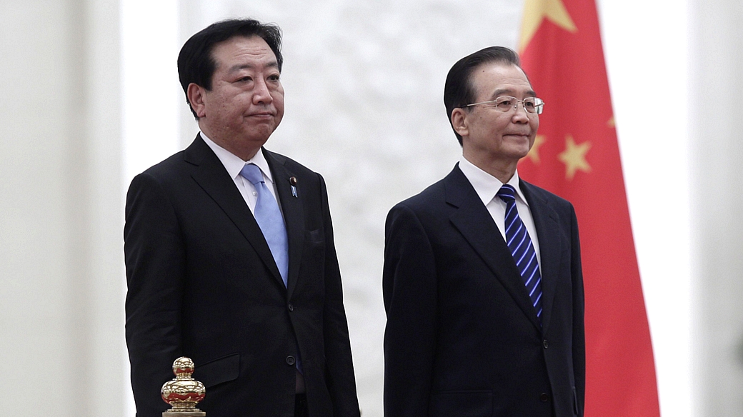 O primeiro-ministro japonês, Yoshihiko Noda, e o premiê chinês, Wen Jiabao, ouvem os hinos nacionais de seus países durante cerimônia em Beijing