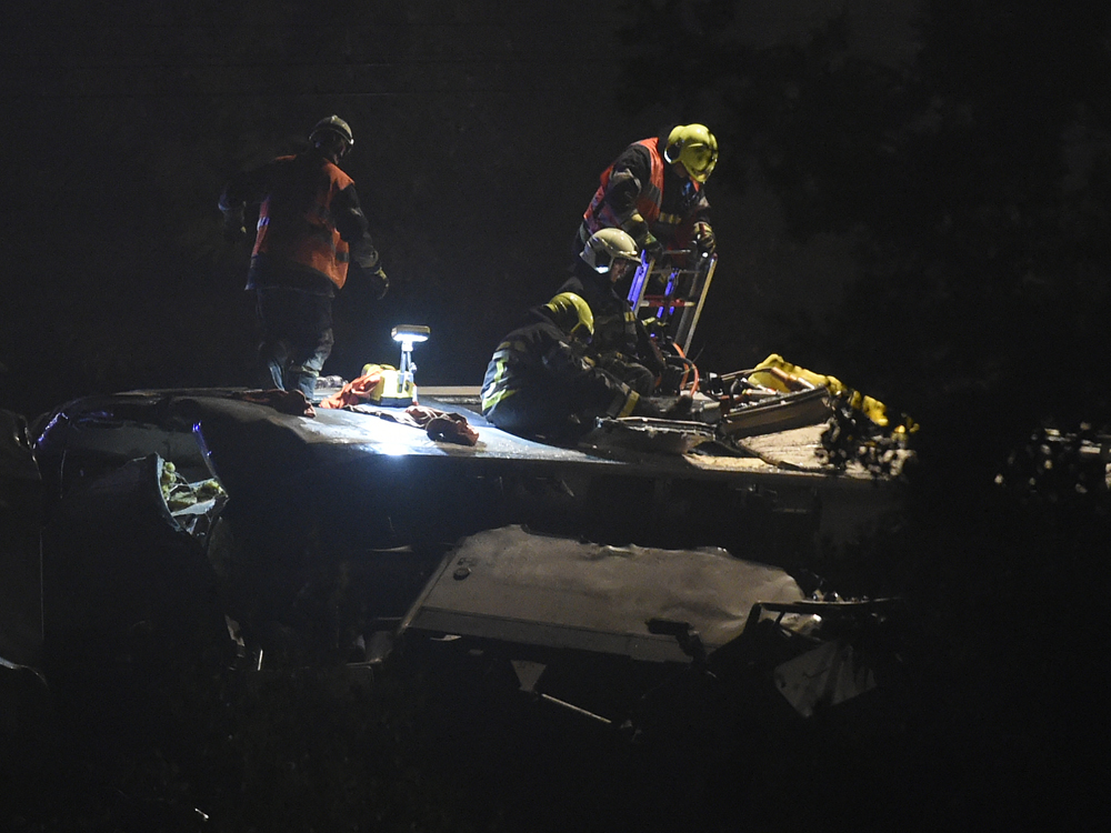 Socorristas trabalham no telhado do trem de passageiros que colidiu com um trem de mercadorias na Bélgica, neste domingo