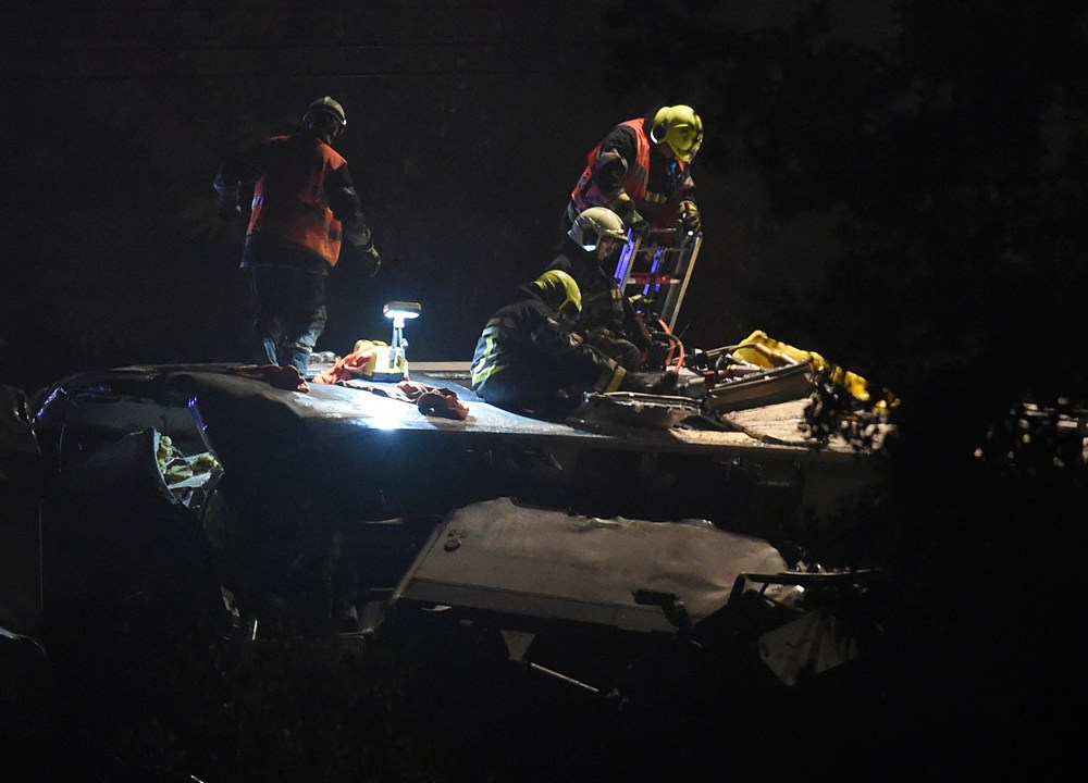 Socorristas trabalham no telhado do trem de passageiros que colidiu com um trem de mercadorias na Bélgica, neste domingo