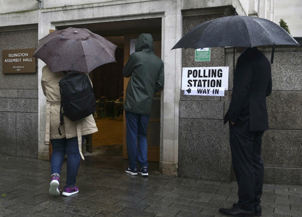 Eleitores protegem-se da chuva em Londres