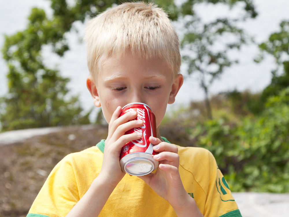 Criança bebendo coca-cola
