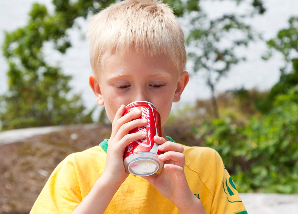 Criança bebendo coca-cola