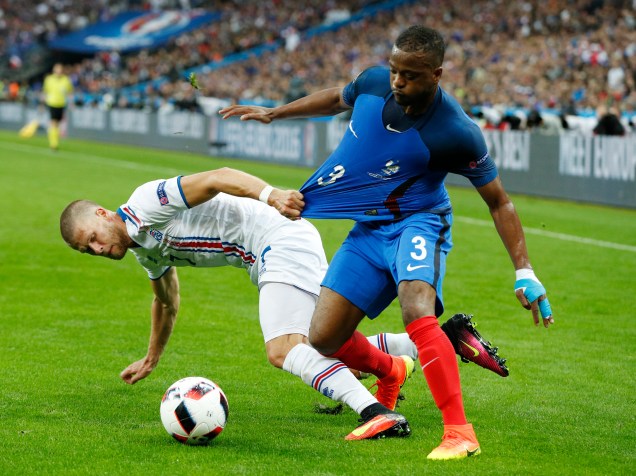 Patrice Evra da França divide jogada com o islandês Johann Gudmundsson