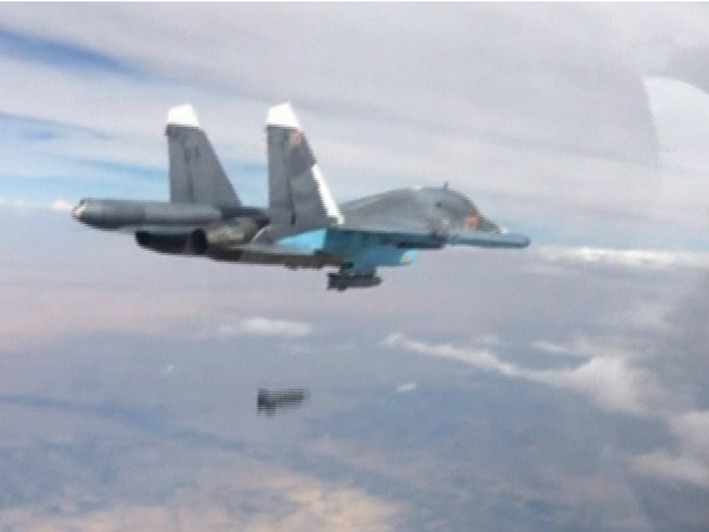 Caça russo, fotografado pela janela de outro avião, lança bomba na Síria