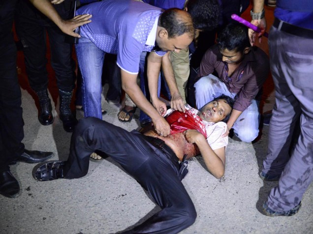 Homem ferido é carregado para fora do restaurante atacado a tiros por terroristas em Daca, Bangladesh - 01/07/2016