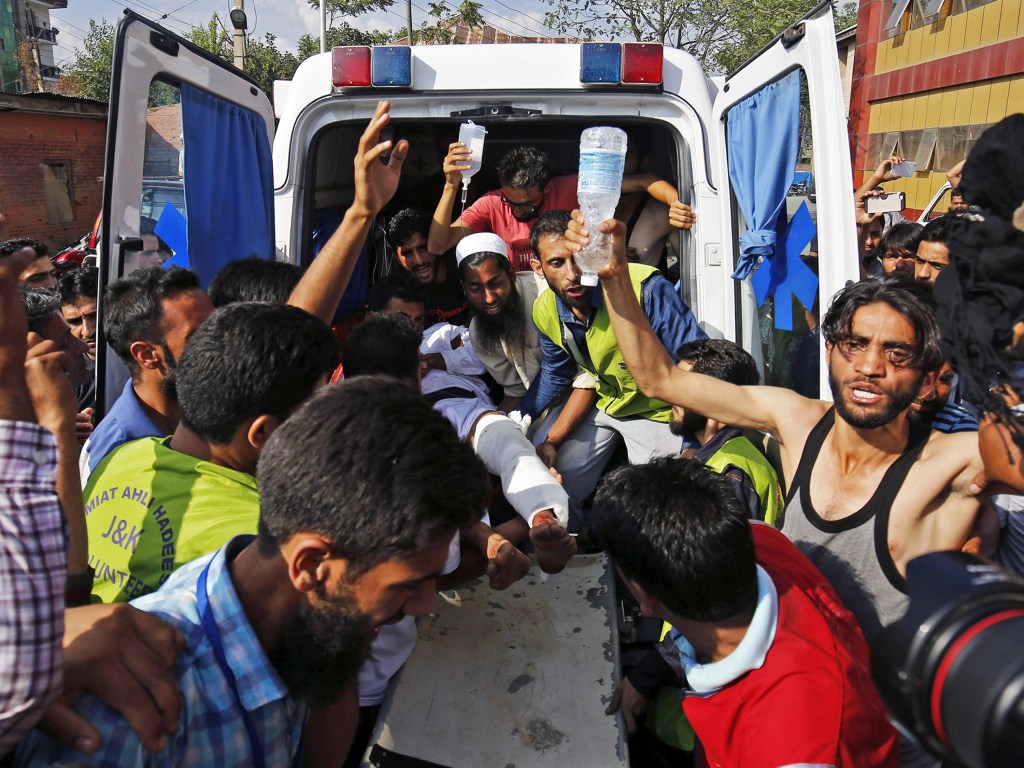 Voluntários carregam homem ferido para uma ambulância, durante confronto entre policiais e manifestantes, em protestos ocorridos após a morte de Burhan Wani, líder do grupo separatista Hizbul Mujahideen, na região indiana da Caxemira - 11/07/2016