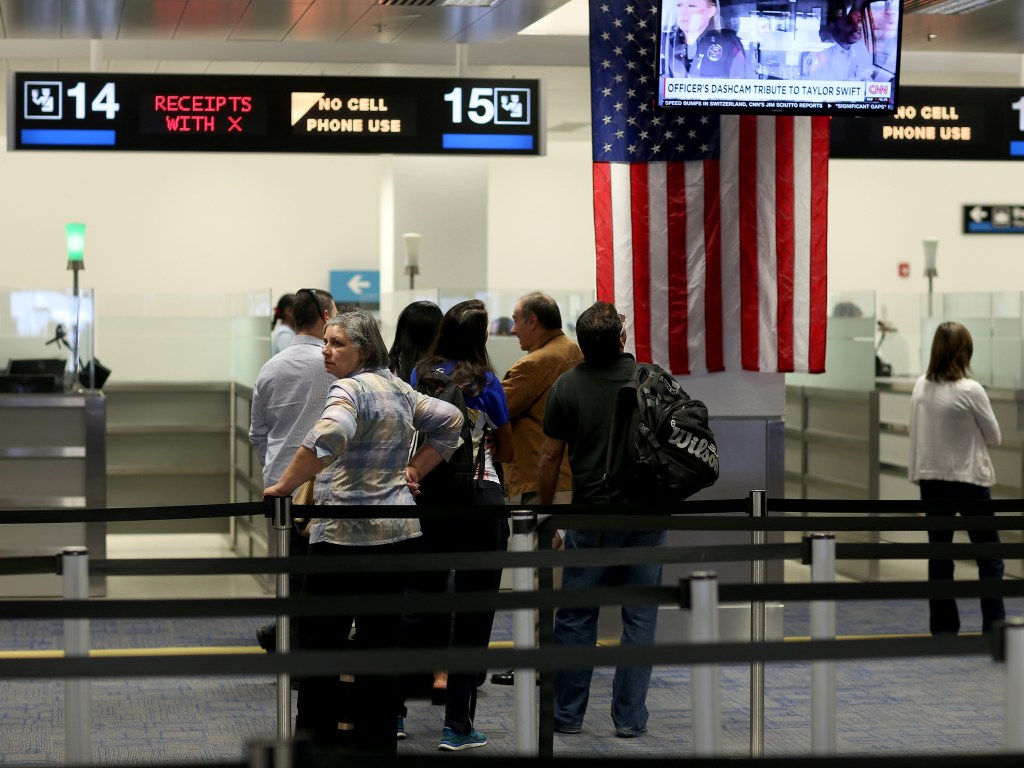 Viajantes estrangeiros esperam na fila do controle de imigração no Aeroporto Internacional de Miami, na Flórida (EUA)