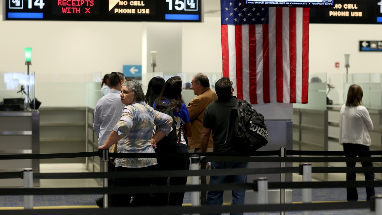Viajantes estrangeiros esperam na fila do controle de imigração no Aeroporto Internacional de Miami, na Flórida (EUA)