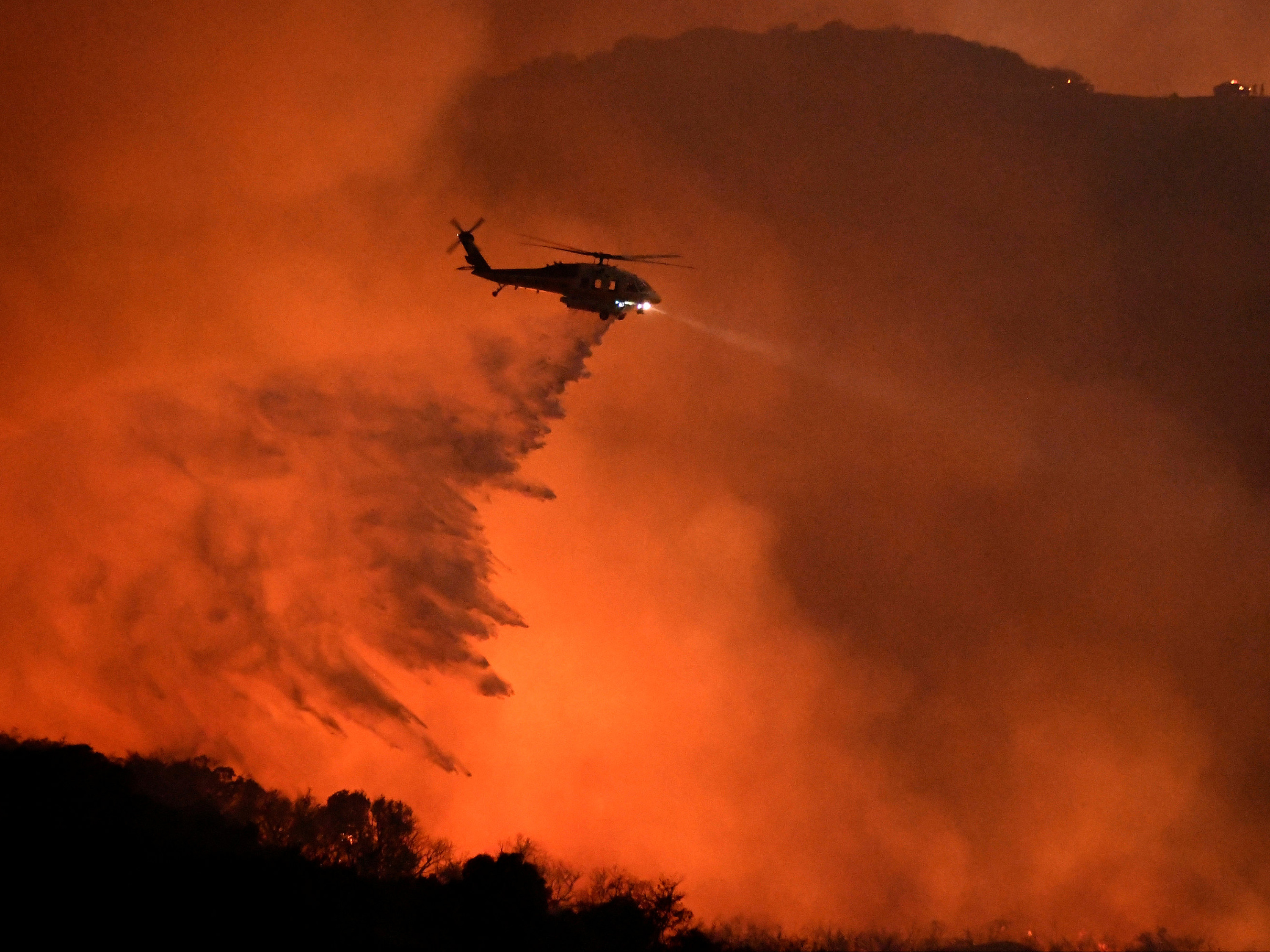 Helicóptero trabalha no combate de um incêndio florestal em Calabasas, Califórnia (EUA)