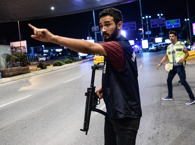 Policial turco orienta passageiros na entrada principal do Aeroporto Ataturk, em Istambul, na Turquia. Atentado terrorista deixou 41 mortos e centenas de feridos no local - 28/06/2016