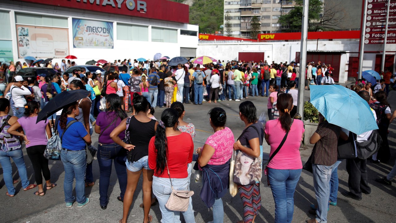 Pessoas tentam comprar papel higiênico e fraldas em uma farmácia em Caracas, na Venezuela