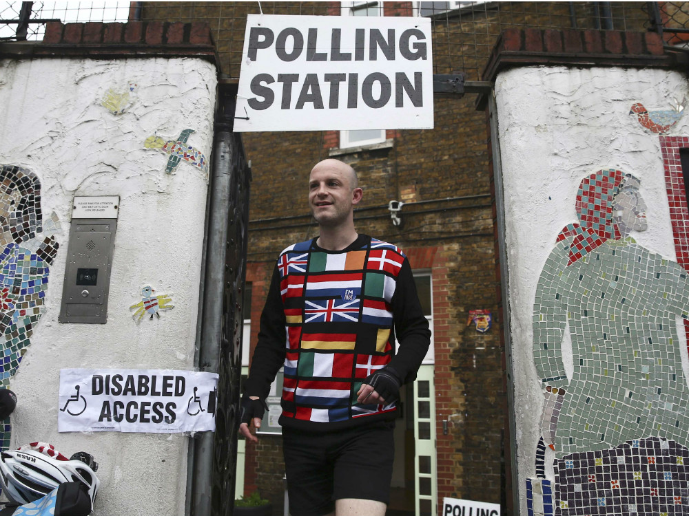 Um eleitor vestido com as bandeiras europeias deixa o local de votação, em Londres