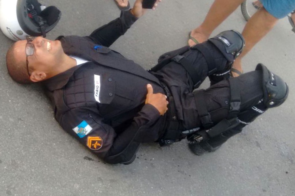 Cabo Fabio Alves deitado no chão após ser baleado, no Rio