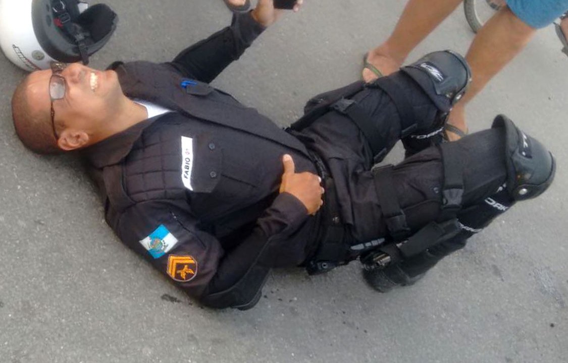 Cabo Fabio Alves deitado no chão após ser baleado, no Rio