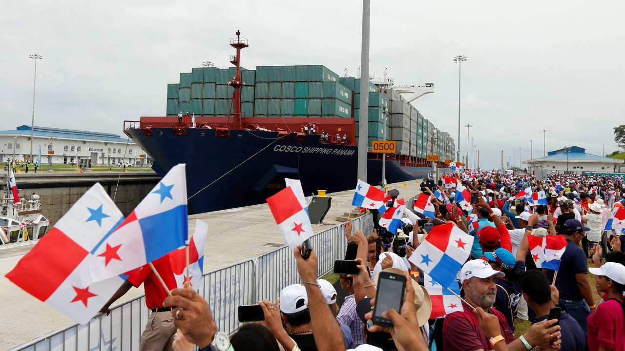 Panamenhos agitam bandeiras do país durante a passagem de Andronikos, embarcação que inaugura a ampliação do canal