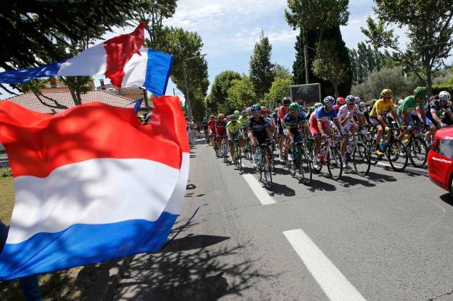 Ciclistas, participantes da competição de bicicleta "Tour de France" passam pela parada do Dia da Bastilha, comemorada anualmente na frança pelo sucesso da Revolução Francesa de 1789