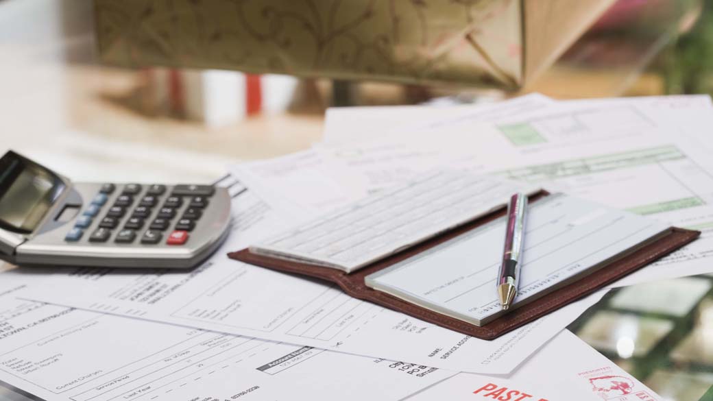 Mesa com papeis, cheques e calculadora