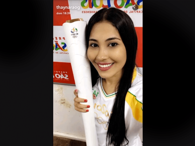 Thaynara Og segura a tocha olímpica, em São Luís do Maranhão, cidade natal da snapchater