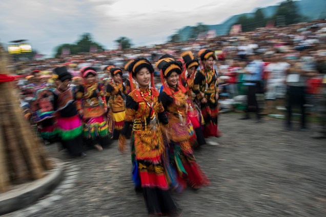 Dançarinas, com trajes tradicionais, se apresentam durante o Festival da Tocha, em Xichang, na China - 27/07/2016