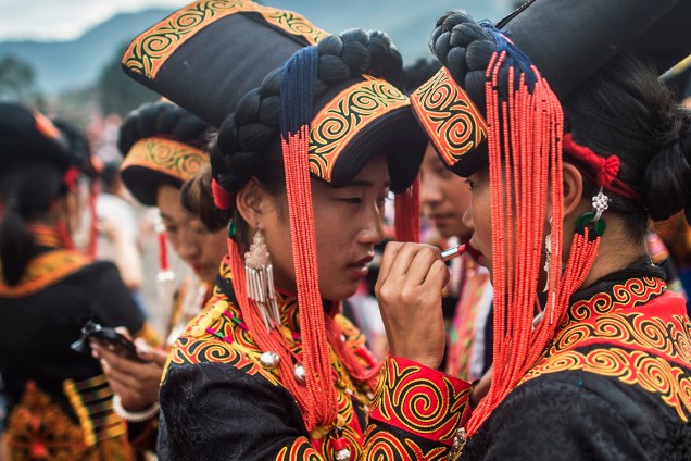 Dançarinas, com trajes tradicionais, se maqueiam durante o Festival da Tocha, em Xichang, na China - 27/07/2016