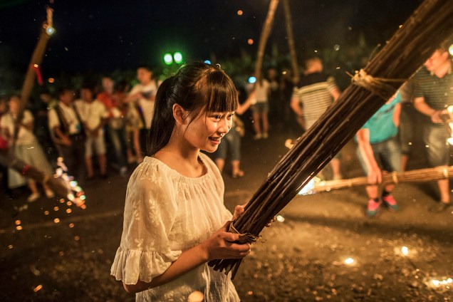 Pessoas participam do Festival da Tocha, em Xichang, na China - 27/07/2016