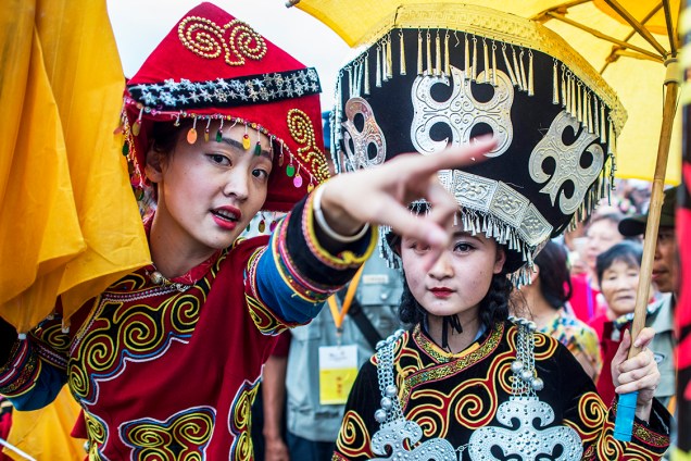 Dançarinas, vestidos com trajes tradicionais, conversam entre si, durante oo Festival da tocha, em Xichang, na província de Sichuan, na China - 27/07/2016