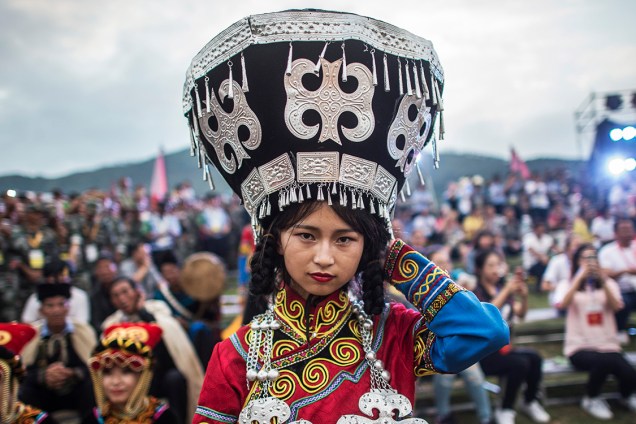 Dançarinas, vestidos com trajes tradicionais, se apresentam no Festival da tocha, em Xichang, na província de Sichuan, na China - 27/07/2016