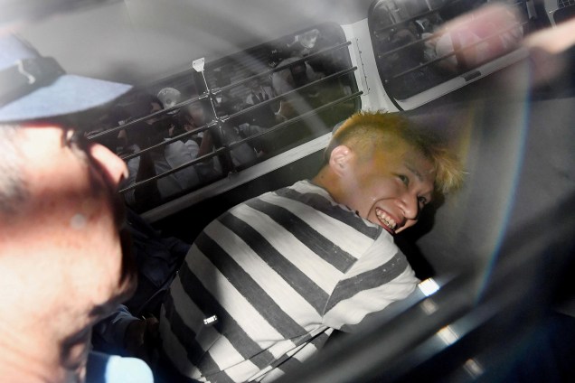 O japonês Satoshi Uematsu, suspeito de ter assassinado 19 pessoas em um centro para deficientes mentais sorriu ao ser fotografado pela imprensa enquanto chegava para um interrogatório - 27/07/2016