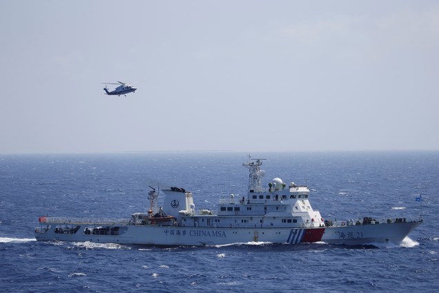 Um navio e um helicóptero chinês são vistos durante exercício de busca e salvamento nas Ilhas Xisha, no Mar do Sul da China - 14/07/2016
