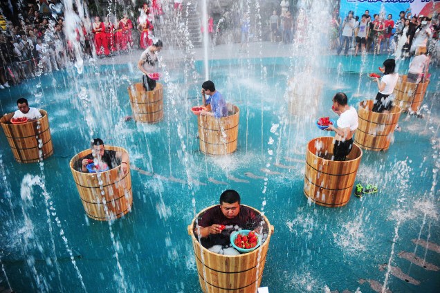 Competidores comem pimentões enquanto tomam banho de água gelada em um evento para ver quem come mais em menos tempo em Hangzhou, na China - 21/07/2016
