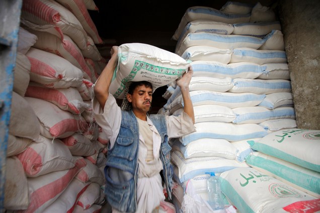 Trabalhador carrega um sacos de farinha em uma loja em Sanaa, no Iêmen - 14/07/2016