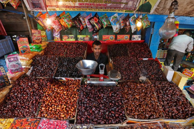 Vendedor de frutas e sementes aguarda clientes em um mercado na cidade de Mumbai, na Índia - 25/05/2016