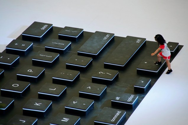 Criança sobe em um teclado gigante montado para uma promoção em um shopping de Pequim, na China - 28/07/2016
