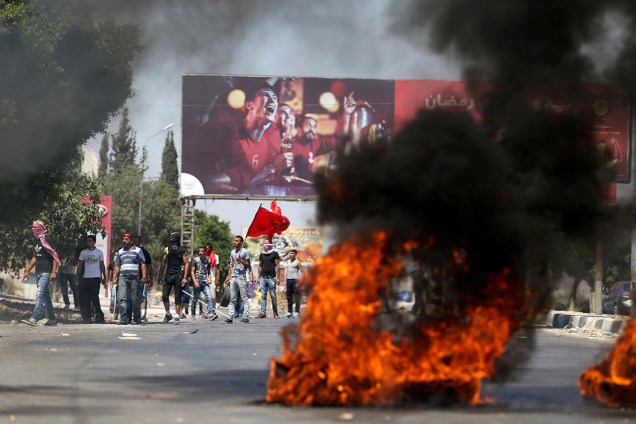 Manifestantes palestinos queimam pneus durante protesto em que houve confronto com a polícia israelita, na cidade de Nablus - 29/07/2016