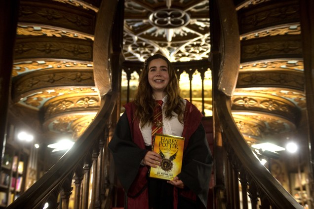 Fã da franquia Harry Potter posa fantasiada com novo exemplar do livro Harry Potter e a Criança Amaldiçoada, lançado ontem