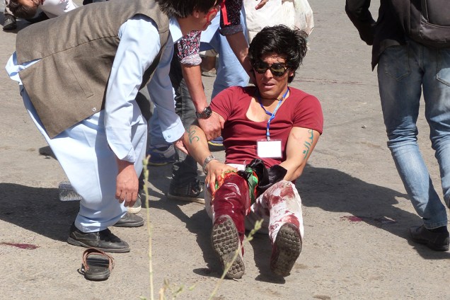 Pessoas ajudam homem ferido após homens-bomba se explodirem em Cabul, no Afeganistão - 23/07/2016