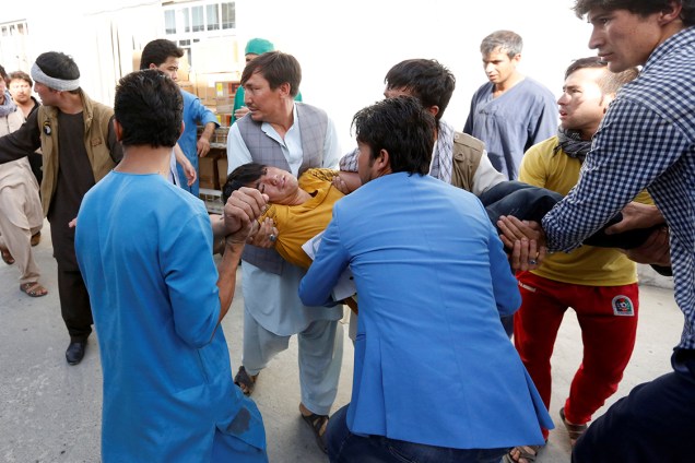 Homens carregam ferido, após homens-bomba se explodirem na cidade de Cabul, no Afeganistão. O grupo Estado Islâmico reivindicou a autoria do ataque - 23/07/2016