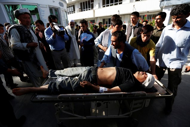 Homem ferido é carregado em uma maca, após homens-bomba se explodirem, durante protesto em Cabul, no Afeganistão. O grupo Estado Islâmico reivindicou a autoria do ataque - 23/07/2016