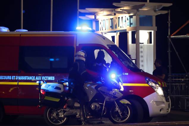 Oficiais de polícia e bombeiros próximos ao local onde dezenas de pessoas foram mortas, após serem atropeladas, durante as comemorações do 'Dia da Queda da Bastilha', em Nice, na França - 14/07/2016