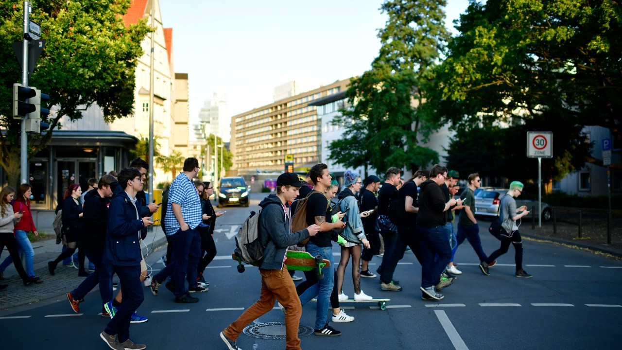 Jovens andam pelo centro de Hanover, na Alemanha, enquanto jogam 'Pokémon Go', game de realidade aumentada desenvolvido pela Nintendo - 15/07/2016