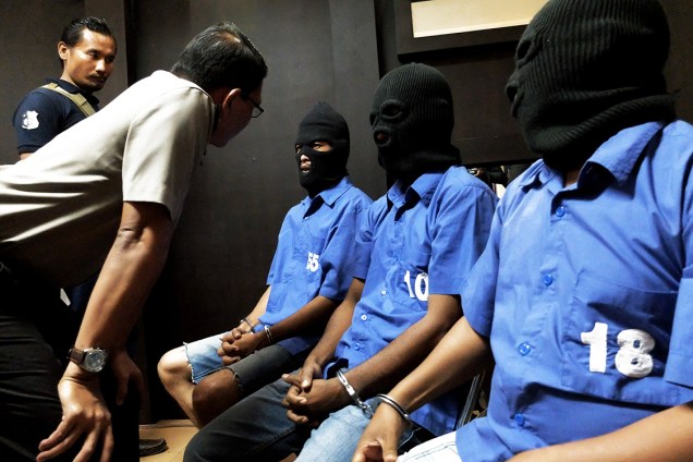 Três indonésios que contrabandearam 60 kg de metanfetamina de Camarões e da Malásia, são interrogados por policiais, antes de entrevista coletiva em Jacarta - 27/07/2016