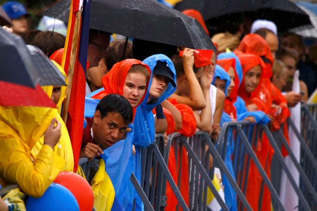 Peregrinos aguardam sob forte chuva, a passagem do Papa Francisco pelas ruas de Cracóvia, na Polônia. Pontífice participará da Jornada Mundial da Juventude no país - 27/07/2016