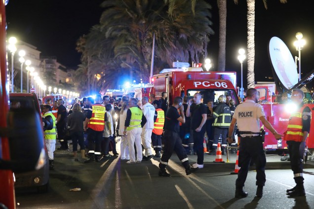 Policiais, bombeiros e equipes de resgate trabalham no local de um ataque com um caminhão que avançou contra a multidão durante as celebrações do Dia da Bastilha em Nice, na França - 14/07/2016