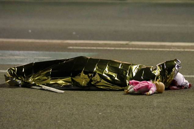O corpo de uma criança é visto ao lado de uma boneca  após um caminhão avançar para a multidão que comemorava o Dia da Bastilha em Nice, na França - 15/07/2016