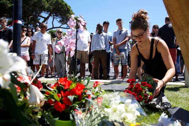 Mulher coloca um buquê de flores em homenagem às vítimas no local do ataque com um caminhão em Nice, na França - 15/07/2016