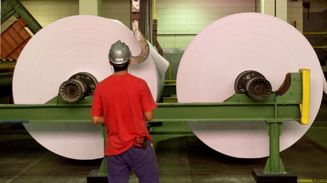 Funcionário observa bobinas de papel na unidade industrial da Cia. Suzano de Papel e Celulose, em Suzano, São Paulo